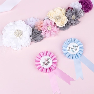 Detailed view of floral Mom to Be sash and matching Mommy and Daddy rosette badges