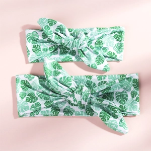 Detail of parent and child matching headbands with green tropical palm leaf prints