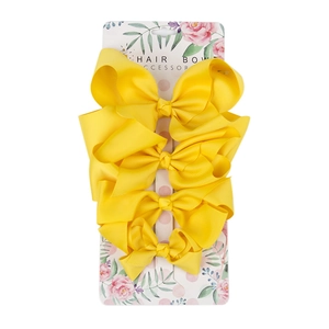 Set of four yellow grosgrain ribbon hair bows in various sizes on retail display card