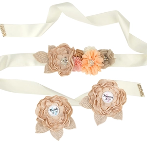 Detailed view of Mommy to Be sash and Daddy to Be pins with floral and pearl accents