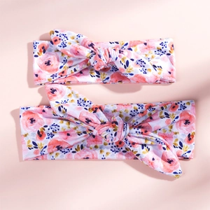 Close-up of mother and baby floral rabbit ear headbands with soft pink flower patterns