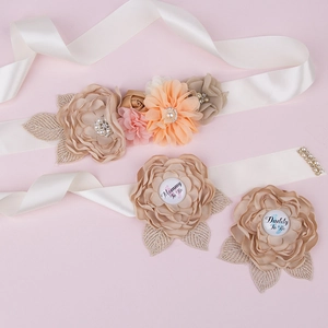 Detail of baby shower sash with handmade flowers and Mommy and Daddy To Be badges