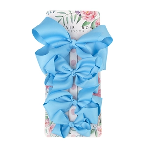 Set of four light blue grosgrain ribbon hair bows in varying sizes on display card