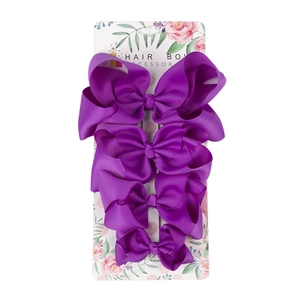 Set of four purple grosgrain ribbon hair bows on display card for girls