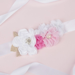 Detailed macro view of handmade chiffon floral sash with faux pearls and gold leaf accents