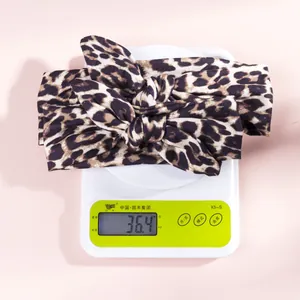 Detailed view of leopard print knotted headband on a scale showing 36.4g weight