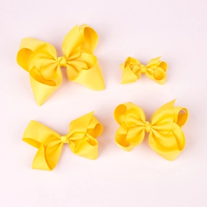 Set of four yellow grosgrain ribbon hair bows in varying sizes for girls styling