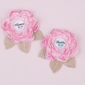 Close-up of pink satin Mommy to Be and Daddy to Be flower corsages for baby shower
