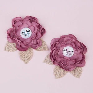 Detailed view of Daddy To Be and Mommy To Be floral badges in dusty pink fabric