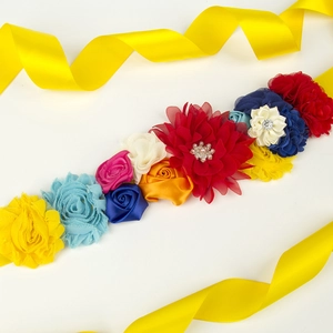 Gros plan détaillé de fleurs en tissu colorées faites main avec perles et strass sur ruban jaune