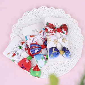 Detailed close-up of Christmas grosgrain ribbon hair bows with Santa and reindeer prints