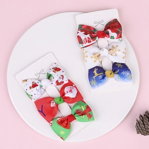 Detailed view of six Christmas ribbon hair clips on white cards with holiday patterns
