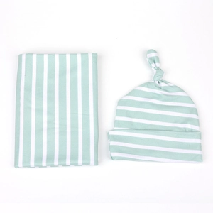 Détails de la couverture d'emmaillotage rayée vert menthe et du bonnet noué assorti