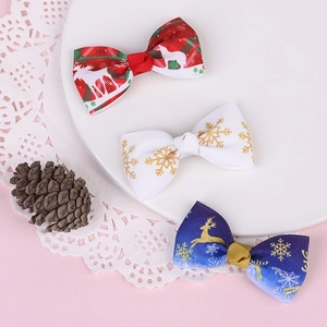 Detailed view of three festive Christmas bow hair clips on a white display plate