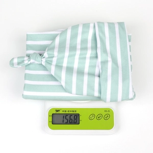 Détail macro montrant le poids de l'ensemble couverture à rayures vertes pour bébé
