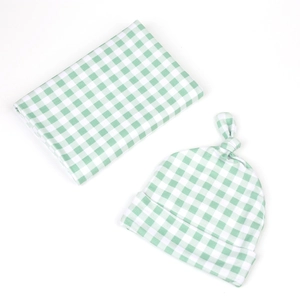 Detail showing green gingham baby swaddle blanket and matching knotted hat set