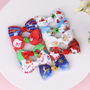 Detail of Christmas bow hair clips with festive reindeer and Santa Claus printed patterns
