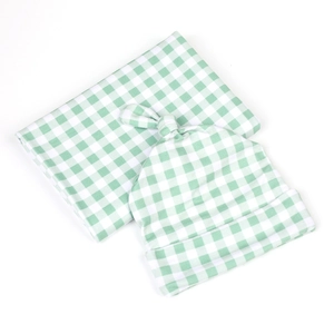 Detail of green and white gingham swaddle blanket with matching knotted baby hat