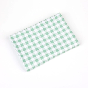 Detail of green gingham swaddle fabric with soft cotton texture and woven pattern