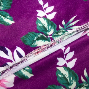 Detail of purple floral maternity robe fabric showing clean white overlock stitching seams