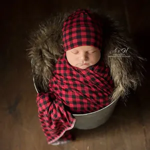Detail view of red and black buffalo plaid newborn swaddle set and matching round hat