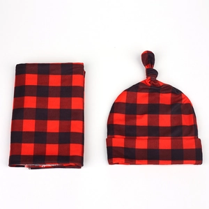Detailed view of baby hat and scarf set in classic red and black buffalo plaid pattern