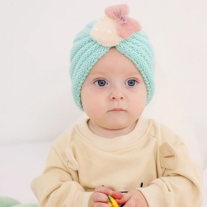 Détails du bonnet tricoté vert menthe pour bébé avec un nœud en peluche et une perle
