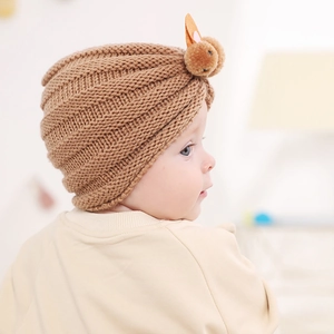Close-up of khaki knit baby turban hat featuring cute 3D plush rabbit ears and ribbed texture