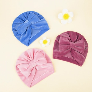 Trois bonnets turban pour bébé en velours avec grands nœuds en bleu, rose et rose