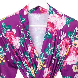Detailed close-up of maternity hospital robe with purple floral patterns and roses
