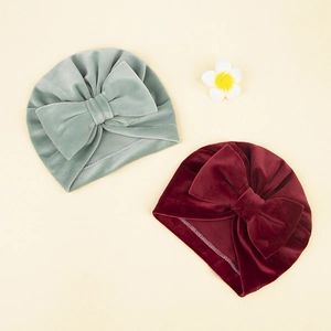 Détail de bonnets turbans pour bébé en velours avec grands nœuds et texture plissée
