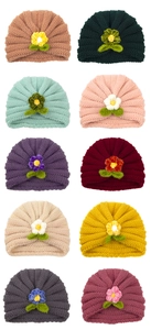 Detail view of ten colors of knit baby hats with crochet flower and leaf accents