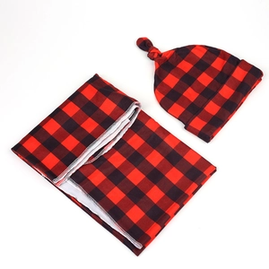 Detail of red and black buffalo check baby swaddle set with knit fabric and white stitching