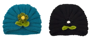 Close-up of knit baby beanies in peacock blue and black with decorative crochet flowers