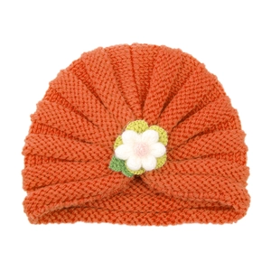 Orange baby knit turban hat with a handmade crochet flower decoration on white background