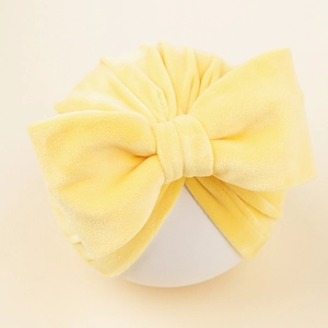 Détail du turban en velours pour bébé avec un grand nœud et une texture plissée