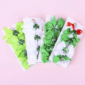 Detailed set of St. Patrick's Day hair clips featuring green shamrocks and glitter bows