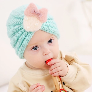 Bonnet en tricot vert menthe pour bébé avec nœud en peluche et détails de perles