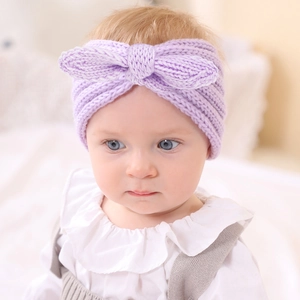 Détail d'un bandeau en tricot violet doux pour bébé avec un grand nœud décoratif