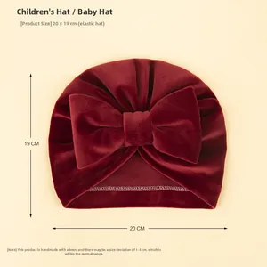 Vue détaillée du bonnet bébé en velours bordeaux avec taille 20x19cm et nœud fait main