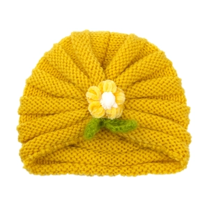 Yellow knitted baby beanie featuring a handmade 3D crochet flower and green leaf detail