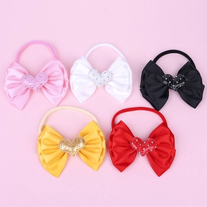 Close-up of five colorful baby nylon headbands with silk bows and glitter heart charms