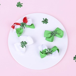 Detail view of 4-piece St. Patrick's Day bow hair clips with green glitter shamrock
