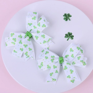 Dettaglio di fermagli per capelli San Patrizio con motivi a trifoglio verde su fiocchi
