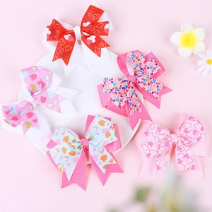 Lot de cinq barrettes à nœuds avec motifs cœurs pour filles sur une assiette blanche