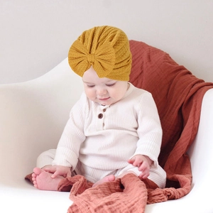 Detailed waffle texture and oversized bow on ginger yellow infant turban hat