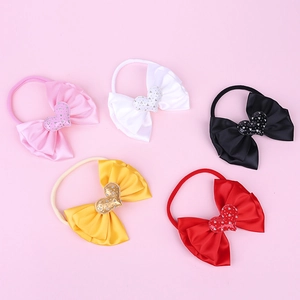 Close-up of five colored baby headbands with satin bows and sequined heart details