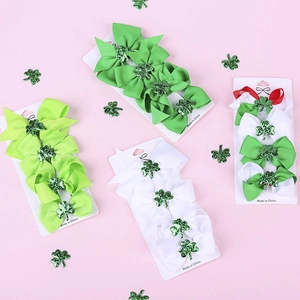 Detailed set of four St. Patrick's Day ribbon hair bows with glitter shamrock centers