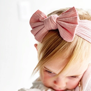 Close-up of baby girl wearing pink ribbed cotton headband with a large decorative bow knot