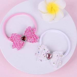 Detail view of baby nylon headbands with sequin bows and heart-shaped rhinestones